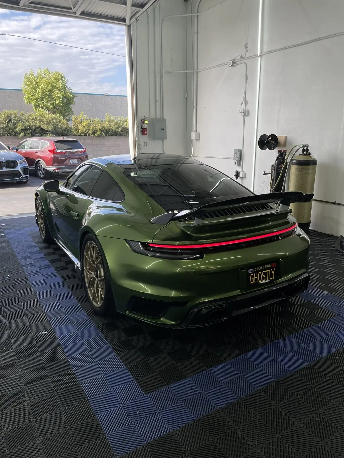 Porsche 911 Turbo S wrapped in Inozetek Metallic Mamba Green vinyl, in the GhostlyAuto bay